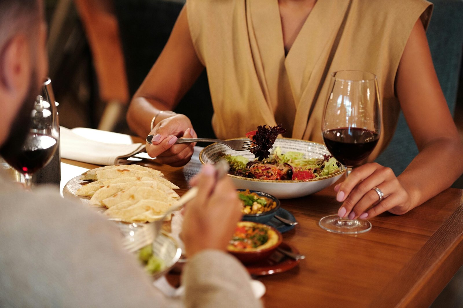 Couple enjoying a romantic dinner with wine and delicious meals at a cozy restaurant.